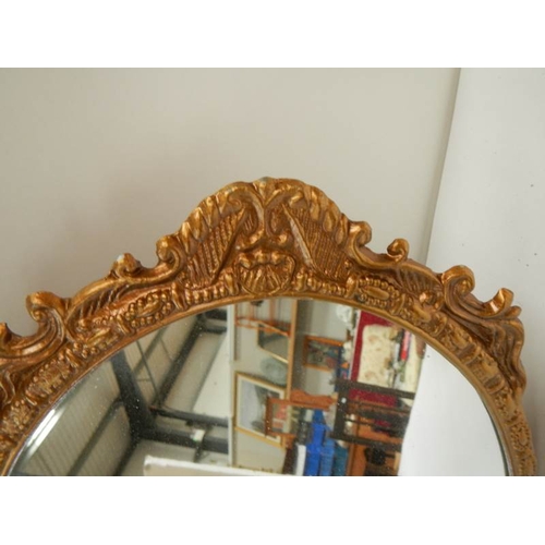 185 - A gilt metal framed oval mirror, in good condition.