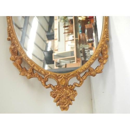 185 - A gilt metal framed oval mirror, in good condition.