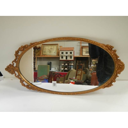 185 - A gilt metal framed oval mirror, in good condition.