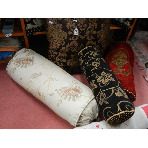 217 - A quantity of 20th century bolster cushions, door draft excluder etc.