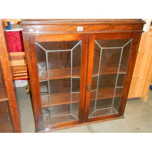 253 - An oak 2 door leaded book case,  35'' wide x 38'' high,