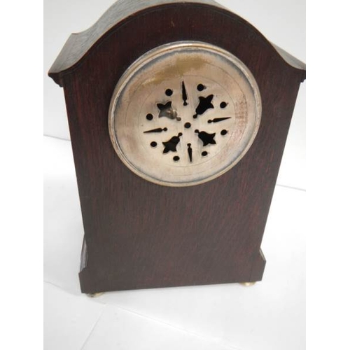 269 - An oak mantel clock in working order complet with key and pendulum (chip on face)