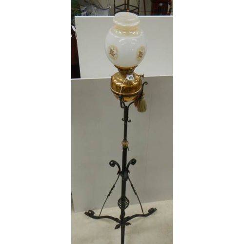 288 - An early 20th century adjustable brass and iron standard oil lamp.