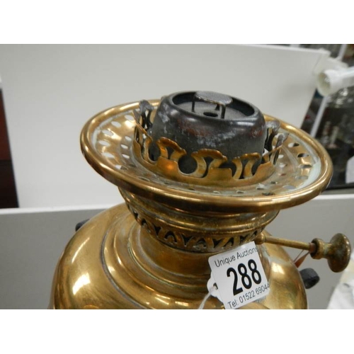 288 - An early 20th century adjustable brass and iron standard oil lamp.