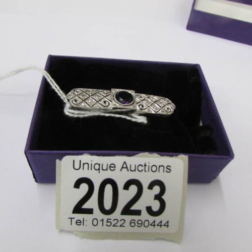 2023 - An Art Deco diamond set brooch with central amethyst set in platinum.