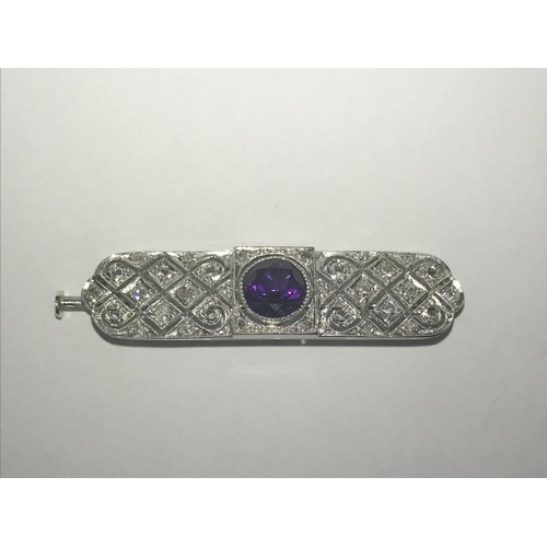 2023 - An Art Deco diamond set brooch with central amethyst set in platinum.