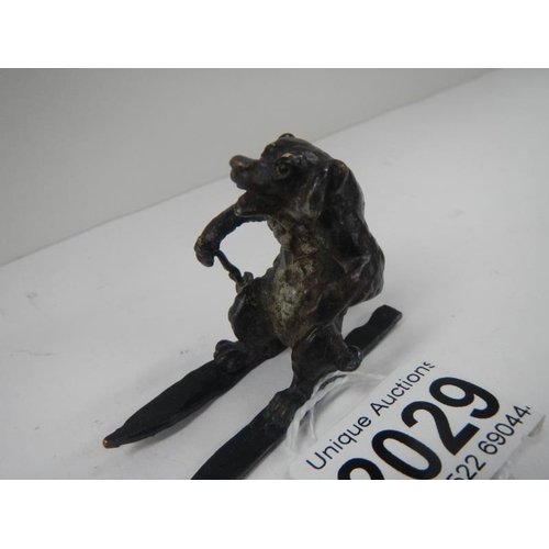 2029 - An early painted bronze of a dog on skis 2 inches high