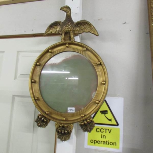 2356 - A gilt framed circular mirror surmounted eagle.