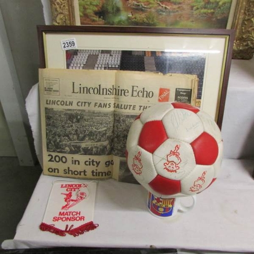 2359 - A signed Lincoln City FC football, 2 LCFC paperweights, a pennant, a 1976 newspaper and a framed and... 