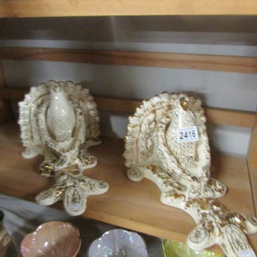 2416 - A pair of ceramic wall brackets featuring a bird on a branch in white and gold, one a/f.