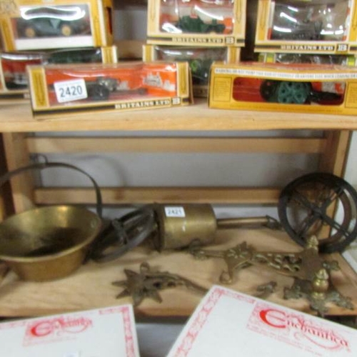 2421 - A Victorian brass spit roaster with wall brackets and a brass saucepan.