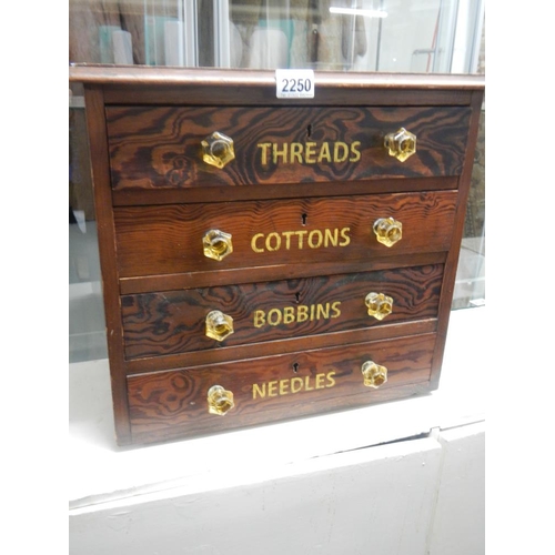 2250 - A small pitch pine chest with 4 drawers advertising cottons and bobbins and threads