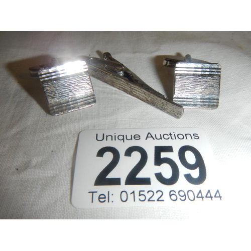 2259 - A pair of silver cuff links and a matching silver tie pin.