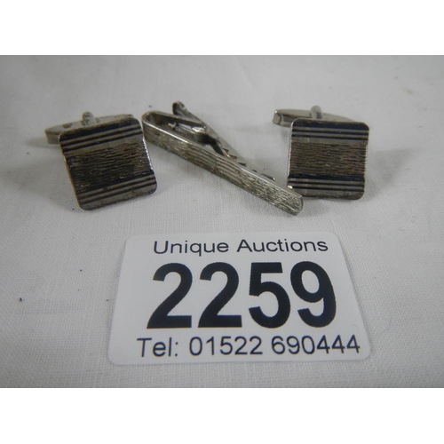 2259 - A pair of silver cuff links and a matching silver tie pin.