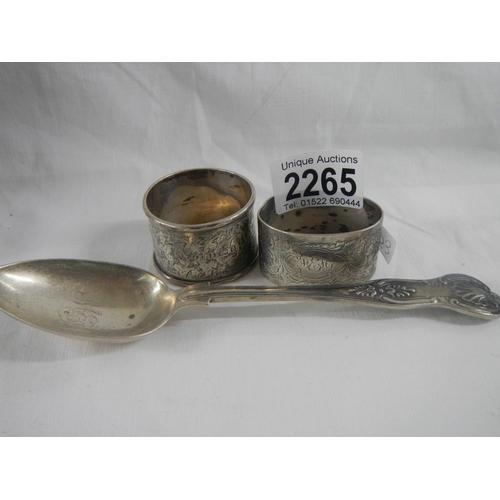 2265 - 2 silver napkin rings and a silver spoon.