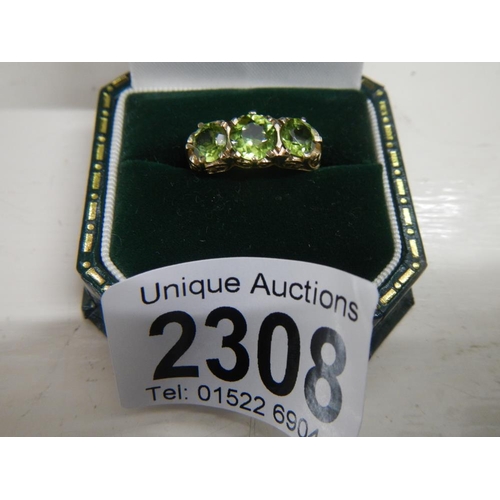 2308 - A stunning deep coloured peridot three stone ring dated London 1972 with a fancy gold work mount in ... 