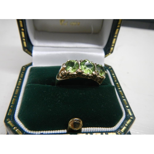 2308 - A stunning deep coloured peridot three stone ring dated London 1972 with a fancy gold work mount in ... 