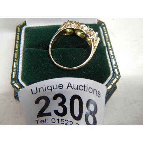 2308 - A stunning deep coloured peridot three stone ring dated London 1972 with a fancy gold work mount in ... 