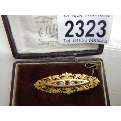 2323 - An antique diamond ruby brooch, hallmarked 15ct gold in a fancy gold cut work setting and in origina... 