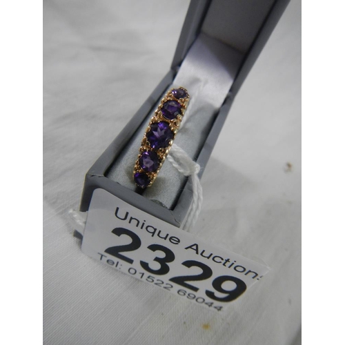 2329 - A 5 stone amethyst set ring dated London 1995, fancy gold work mount in 9ct gold.