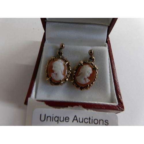 525 - A pair of gold ear pendants set with cameo's of a female profile.