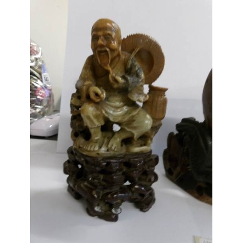 556 - A Chinese soapstone carving depicting a sage figure and a large brush pot decorated with birds and f... 