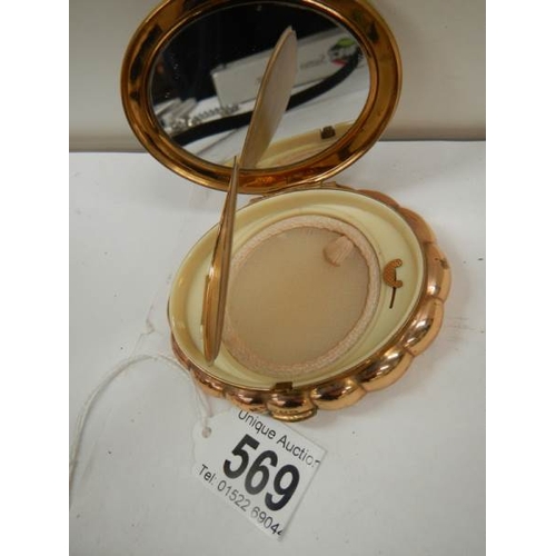 569 - A 1950's oval powder compact with jeweled top, in good condition.