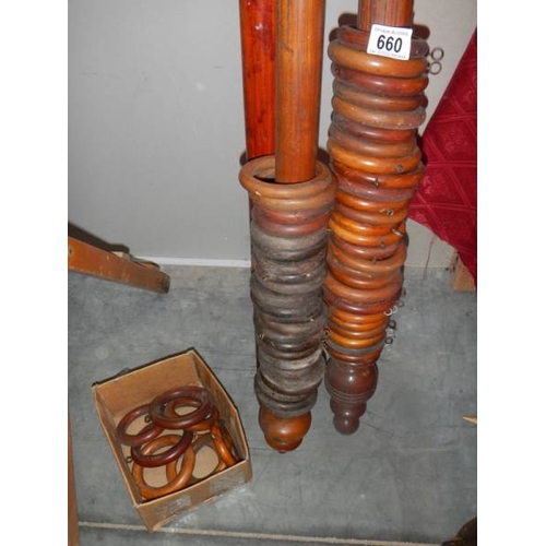 660 - A quantity of Victorian wooden curtain poles with rings.