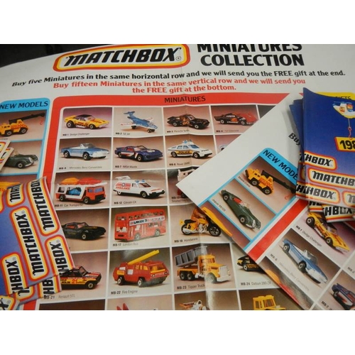 742 - A box of 1983 and 1986 Matchbox toy catalogues and some product posters.