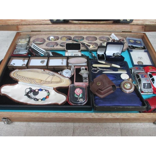 637 - A display case containing assorted jewellery, watches, model cars etc., (this lot is buyer collect o... 