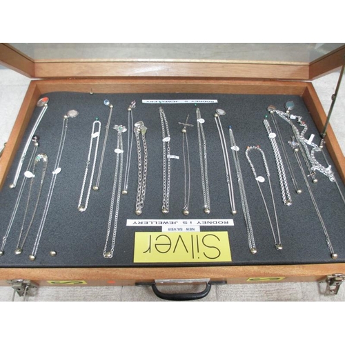 643 - A display case of mainly silver pendants, chains etc., (this lot is buyer collect only).