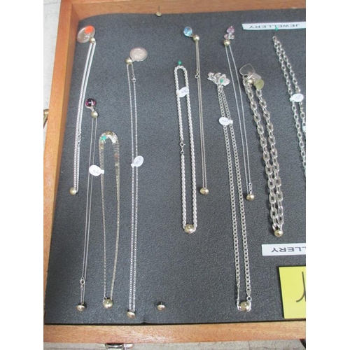 643 - A display case of mainly silver pendants, chains etc., (this lot is buyer collect only).