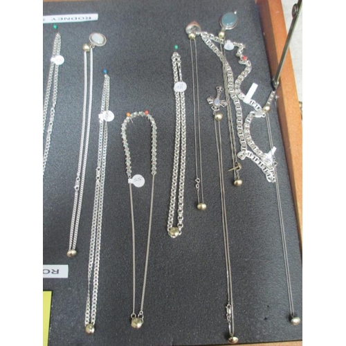 643 - A display case of mainly silver pendants, chains etc., (this lot is buyer collect only).