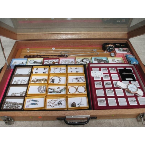 653 - A display case containing silver rings, silver chains, other jewellery and watches etc., (this lot i... 