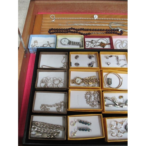 653 - A display case containing silver rings, silver chains, other jewellery and watches etc., (this lot i... 