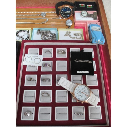 653 - A display case containing silver rings, silver chains, other jewellery and watches etc., (this lot i... 