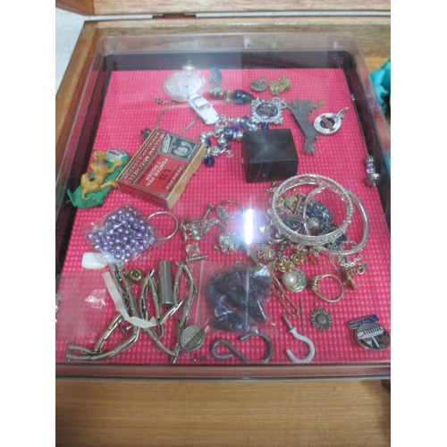 654 - A display case containing miscellaneous badges, jewellery  etc., (this lot is buyer collect only).