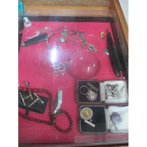 654 - A display case containing miscellaneous badges, jewellery  etc., (this lot is buyer collect only).