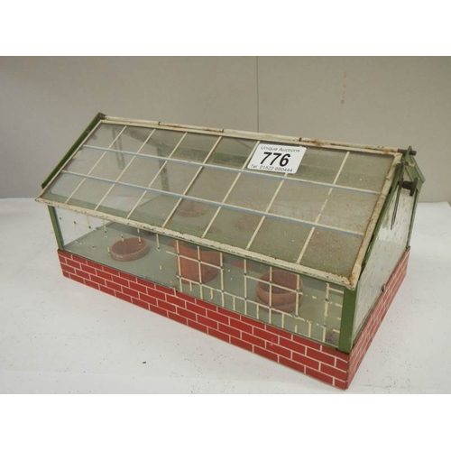 776 - An old model tin green house with lift up roof, catch missing from one side of roof.