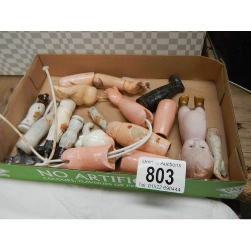 803 - A large mixed lot of doll parts including arms, legs. torsos etc.,