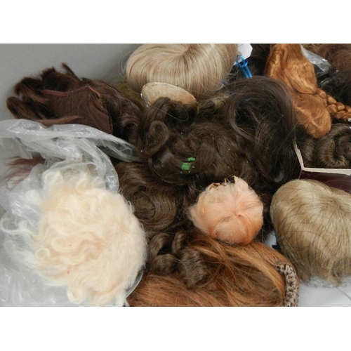 824 - A quantity of dolls wigs.