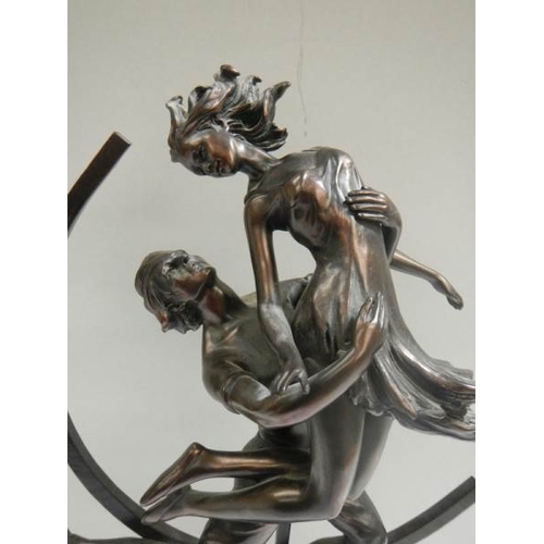 673 - An art deco style figure of a dancing lady with hoop in back ground in a bronzed finish.