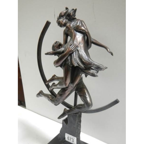 673 - An art deco style figure of a dancing lady with hoop in back ground in a bronzed finish.