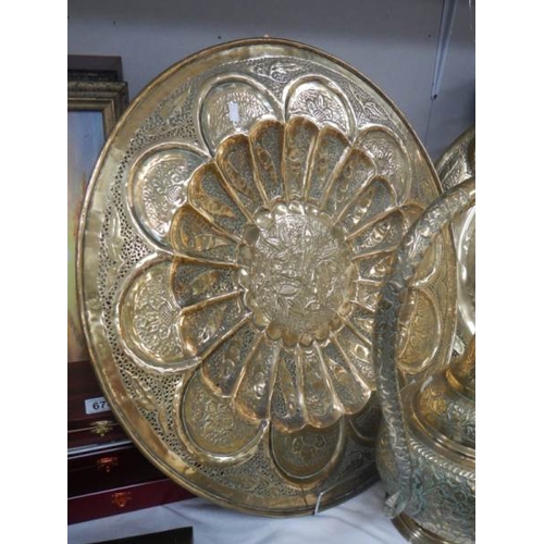 679 - 2 large brass plates and a 22'' tall brass jug.