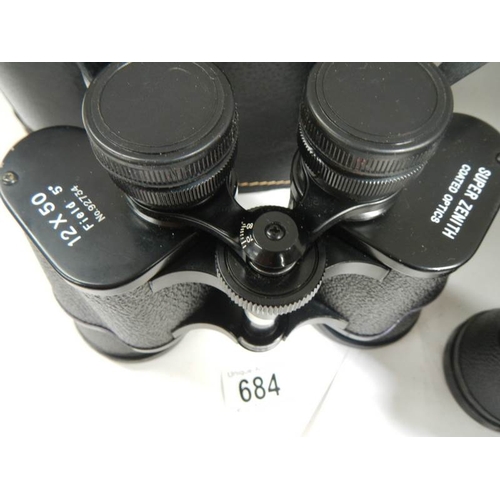 684 - A pair of Super Zenith 12 x 50 binoculars together with  a pair of Optomax 10 x 50 binoculars.