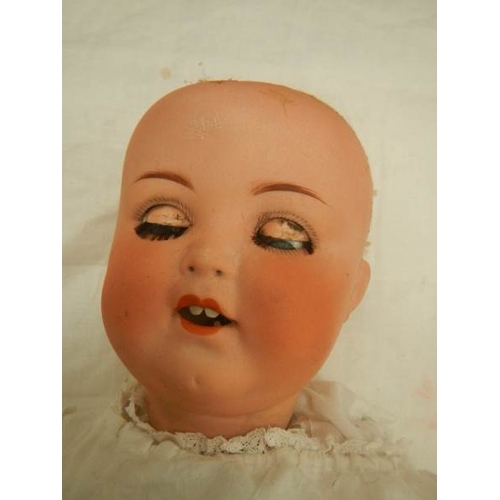 840 - A Victorian porcelain headed doll, missing wig, 18''.