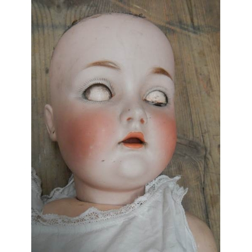 843 - A Victorian porcelain headed doll, missing wig, 27''.