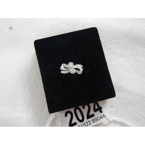 2024 - An 18ct white gold and diamond bow ring.  Size K.