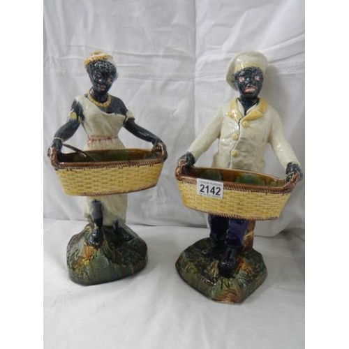 2142 - A pair of majolica style figures, 14.5'' tall.  Repairs to arms and basket on one figure.