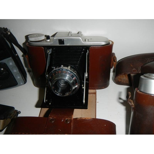 2210 - A pair of binoculars and a quantity of old camera's.